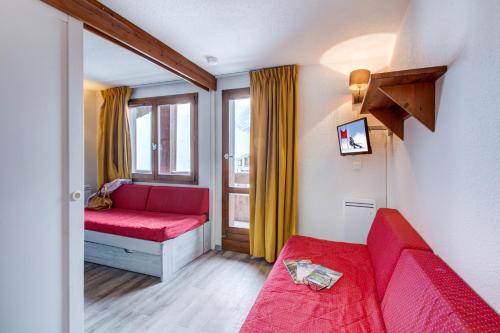 a living room with a red couch and a window at Vacancéole - Le Borsat IV in Tignes