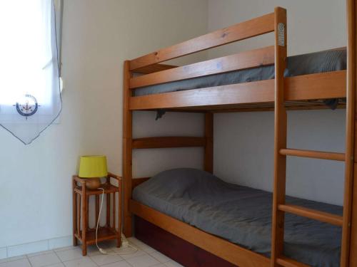 une chambre avec deux lits superposés et une lampe dans l'établissement Appartement en Front de Mer avec Piscine et Parking Privé - 2 Chambres pour 6 Personnes, Saint-Cyprien - FR-1-225D-52, à Saint Cyprien Plage