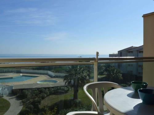 un balcon avec une table et une vue sur l'océan dans l'établissement Appartement en Front de Mer avec Piscine et Parking Privé - 2 Chambres pour 6 Personnes, Saint-Cyprien - FR-1-225D-52, à Saint Cyprien Plage