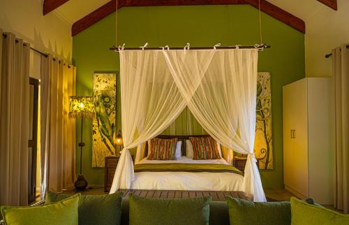 Bee-Eater Cottage في هويدزبروت: غرفة نوم بسرير مع مظلة