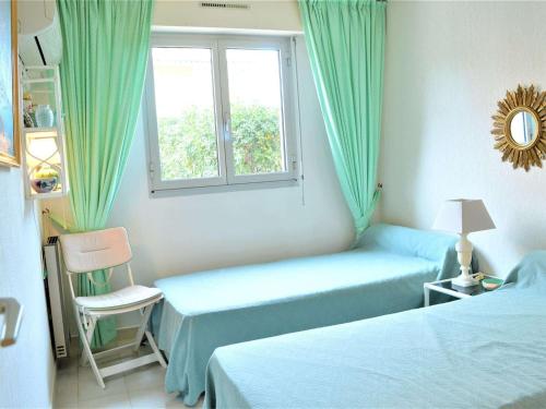 une chambre d'hôtel avec deux lits et une fenêtre dans l'établissement Appartement 3 pièces avec terrasse proche plage à Cavalaire-sur-Mer - FR-1-226B-66, à Cavalaire-sur-Mer