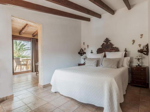 a white bedroom with a bed and a table at Finca Es Torrent in Campos