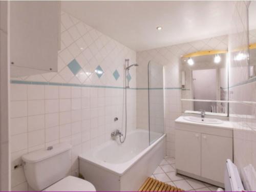 a bathroom with a tub and a toilet and a sink at Maison au centre du village, cour privative, au calme, Wi-Fi, cheminée, idéale pour familles. - FR-1-401-234 in Cauterets