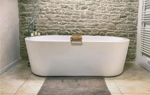 eine weiße Badewanne im Bad mit Ziegelwand in der Unterkunft Nice Home In Raix With Wi-fi 