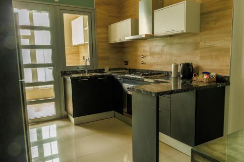 a kitchen with black counters and white cabinets at ALTA VISTA APART HOTEL in Reconquista