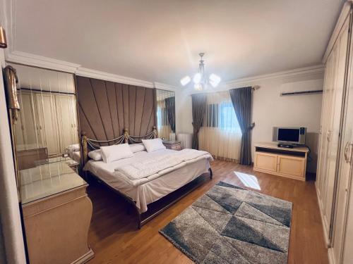 ein Schlafzimmer mit einem großen Bett und einem TV in der Unterkunft شقة تشطيب فندقي موقع متميز عائلات فقط in Kairo