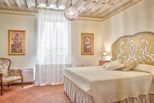 ein Schlafzimmer mit einem Bett, einem Stuhl und einem Fenster in der Unterkunft Casa Sofia - Together in Tuscany in Cortona