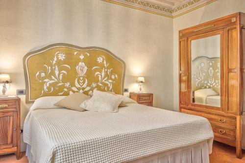 ein Schlafzimmer mit einem Bett und einem großen Spiegel in der Unterkunft Casa Sofia - Together in Tuscany in Cortona