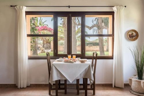 a table with a white table cloth on it in front of a window at Finca Es Torrent in Campos