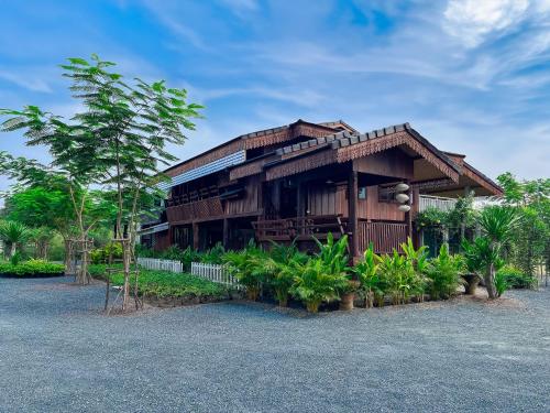 ein Holzhaus mit vielen Pflanzen davor in der Unterkunft North Pine Forest Homestay บ้านไม้สนโฮมสเตย์ in Ban Mae Pong