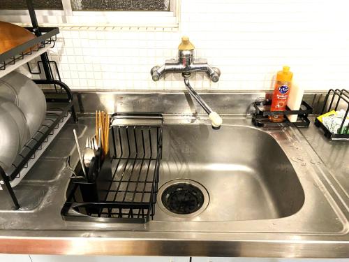 a stainless steel kitchen sink with a dish rack at 港区南麻布・戸建タイプ・ファミリー・8人まで・無料Wi-Fi in Tokyo