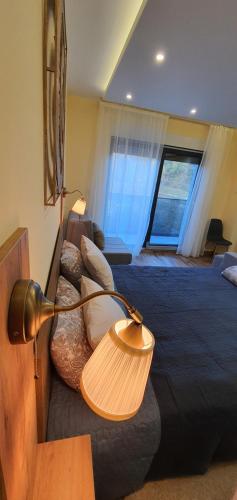 a room with a bed with a lamp and a couch at Studio apartmani Anika in Vrdnik