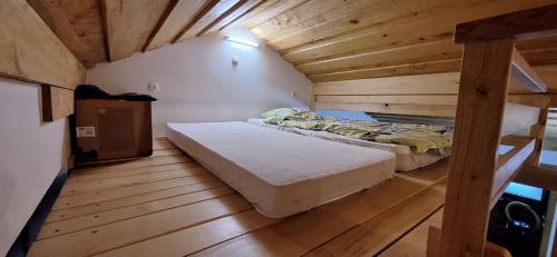 1 dormitorio con 1 cama en una habitación de madera en Prenočišče pri Sodarju en Beltinci