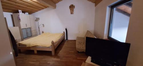 1 dormitorio pequeño con 1 cama y TV en Prenočišče pri Sodarju, en Beltinci