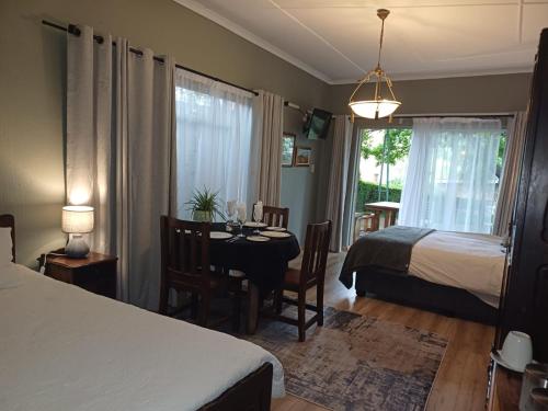 a bedroom with a table and a bed and a table and chairs at The Viewing Deck Accommodation in Clarens