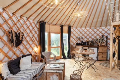- une chambre avec un canapé et une table dans une yourte dans l'établissement Le Moulin des Amis et la Yourte - Atypiques, à La Gouesnière