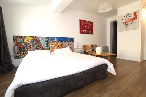 a bedroom with a large white bed and a table at Studio centre historique 200 m de la mairie - Climatisé in Aix-en-Provence