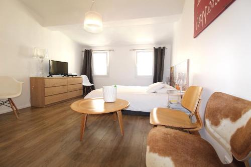 ein Schlafzimmer mit einem Bett, einem Tisch und einem Stuhl in der Unterkunft Studio à 200m de la mairie - Centre historique in Aix-en-Provence