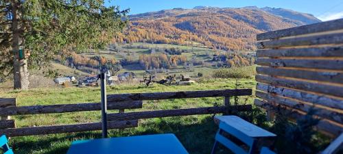 a wooden fence with a table and a view of a mountain at Gîte du Faraud in Le Dévoluy