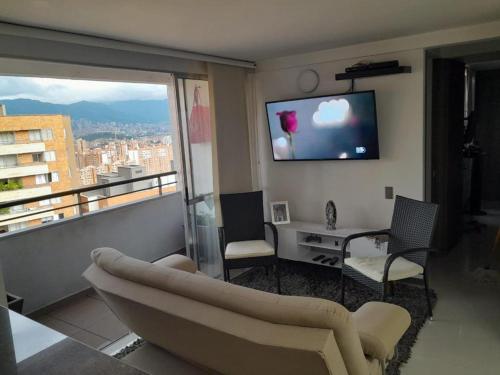 a living room with a couch and a large window at Apartamento inigualable en la ciudad de Medellín excelente vista piso 25 in Medellín