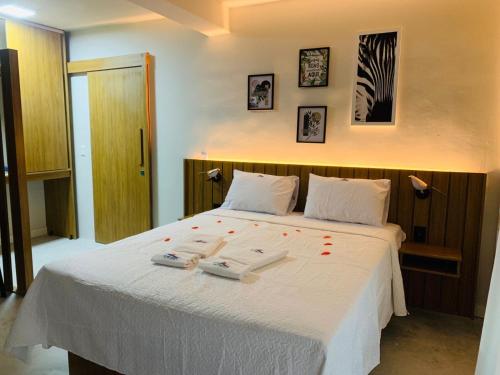 a bedroom with a white bed with two towels on it at LOFTS GREEN ISLAND in Angra dos Reis