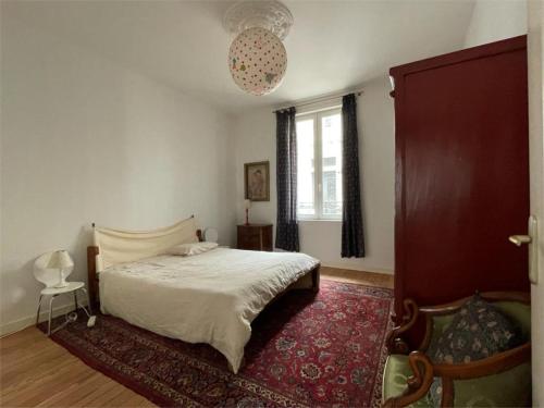 um quarto com uma cama e um tapete vermelho em Appartement cœur de Ville Vichy em Vichy