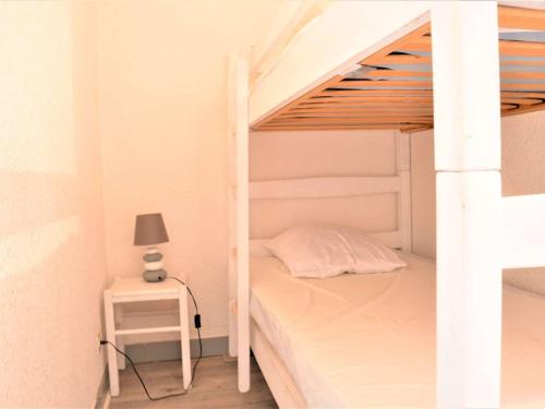 - une chambre avec des lits superposés, une lampe et une table dans l'établissement Studio Cabine avec Terrasse et Parking - Proche Centre et Plages à Cavalaire-sur-Mer - FR-1-226B-31, à Cavalaire-sur-Mer