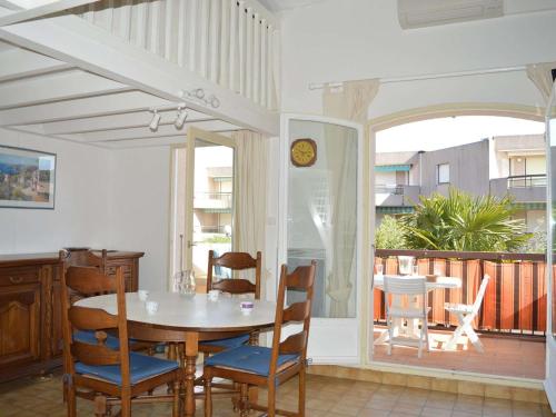 une salle à manger avec une table et des chaises et un balcon dans l'établissement Studio Mezzanine Climatisé avec Terrasse, Parking Privé et Proche Plage à Cavalaire - FR-1-226B-30, à Cavalaire-sur-Mer