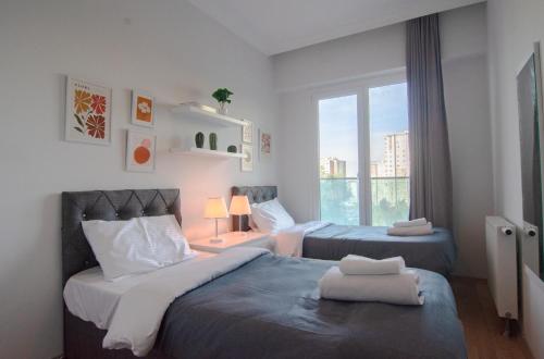 a bedroom with two beds and a window at Charming 3bdr Apt In The Heart Of Halkal Merkez in Istanbul