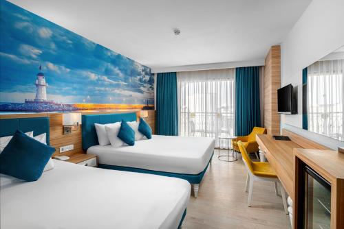 a hotel room with two beds and a television at SUN HEAVEN FAMILY & SPA in Alanya
