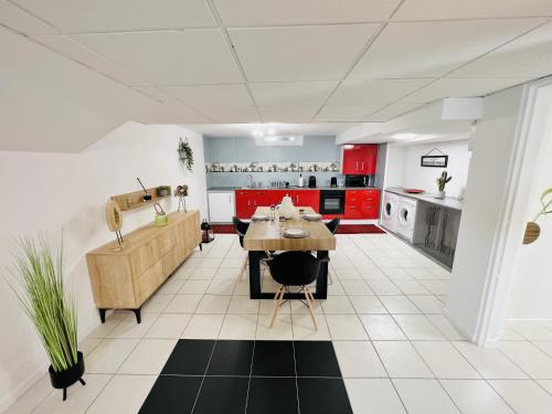 uma cozinha com armários vermelhos e uma mesa em L Autre-Mans - Gare - Atypique - 4 Personnes - Rêve au Mans em Le Mans