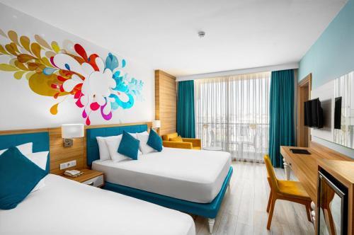 a hotel room with two beds and a tv at SUN HEAVEN FAMILY & SPA in Alanya