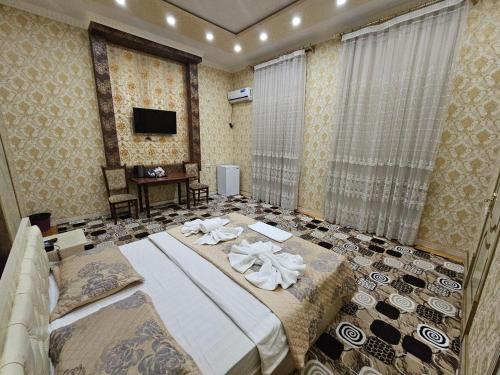 a bedroom with a large bed and a television at Elite Hotel in Tashkent