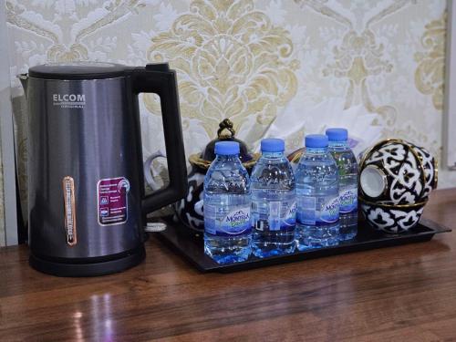 een groep flessen water naast een waterkoker bij Elite Hotel in Tasjkent