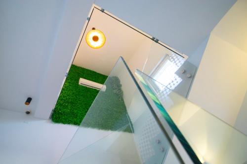 a room with a light on the wall and green grass at ELITE LUXURY BOUTIQUE in Fier