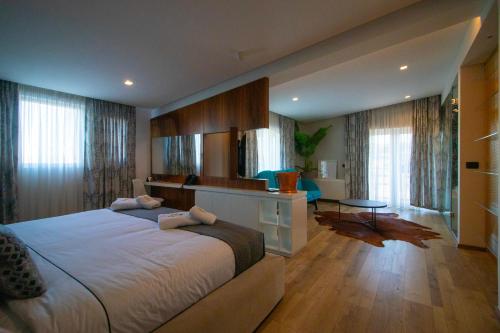 a bedroom with a large bed and a living room at ELITE LUXURY BOUTIQUE in Fier