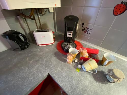 a kitchen counter top with a coffee maker and cups at CHEZ NOUS BIS in Commercy