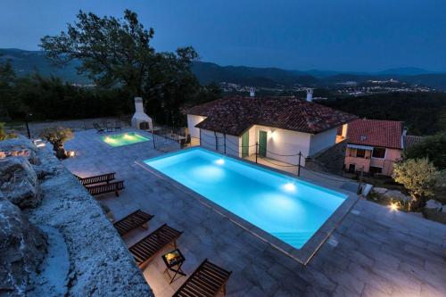 a villa with a swimming pool at night at Villa Lapis in Buzet