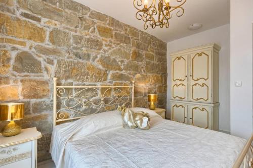 a bedroom with a bed with a stone wall at Villa Lapis in Buzet