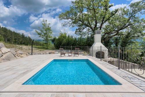 uma piscina com uma mesa e duas cadeiras ao lado em Villa Lapis - Happy Rentals em Buzet