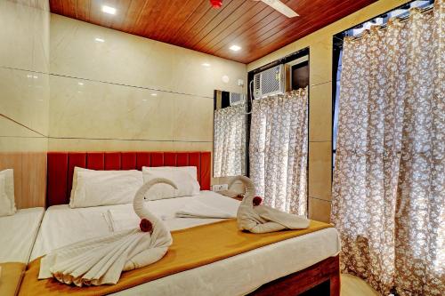 una camera da letto con cigni fatti di asciugamani su un letto di Prince NX Hotel a Thane