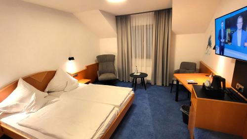 ケール・アム・ラインにあるHotel Schwanenのベッド、デスク、テレビが備わるホテルルームです。