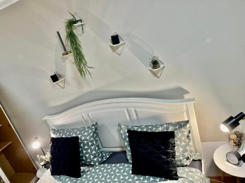 a bedroom with a white bed with black and white pillows at Mc Home Pfungstadt in Pfungstadt
