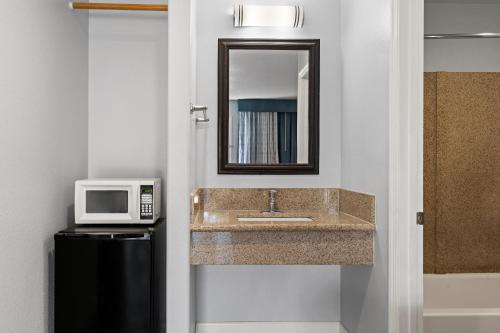 a bathroom with a sink and a microwave at Bay Breeze Inn in Oakland