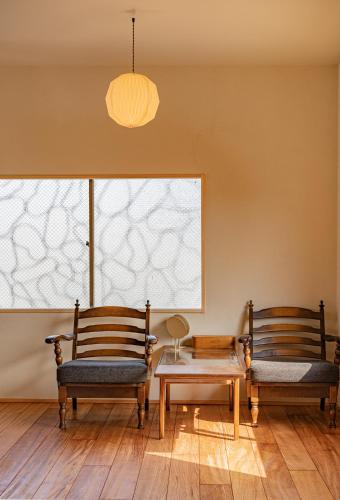 two chairs and a table in a room at 暮らすように過ごすNagi unoport in Uno