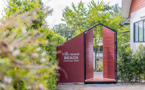 a shed with a red door and a sign that reads wild forest beach at Villa loved beach AO Nam Mao krabi in Ao Nam Mao