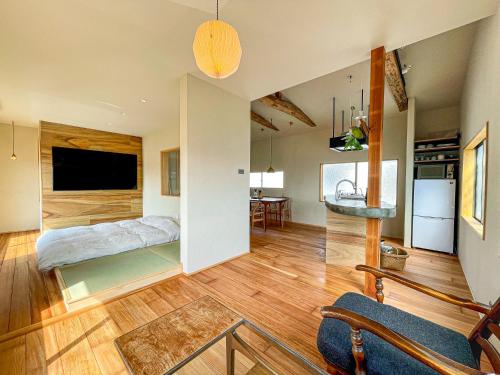 ein großes Wohnzimmer mit einem Bett und einer Küche in der Unterkunft 暮らすように過ごすNagi unoport in Uno