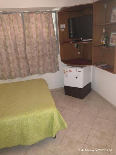 Cette petite chambre comprend un lit et une télévision. dans l'établissement Monoambiente para 2 personas en Neuquen, à Neuquén