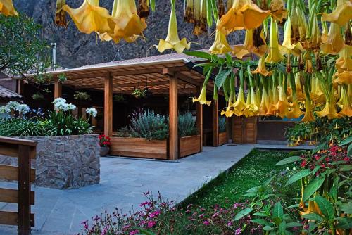 a garden with a bunch of bananas hanging from a structure at Las Qolqas EcoResort Ollantaytambo in Ollantaytambo