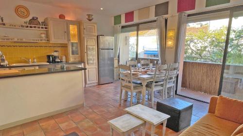 une cuisine avec une table et des chaises dans une pièce dans l'établissement Résidence Catherine, à Sainte-Maxime